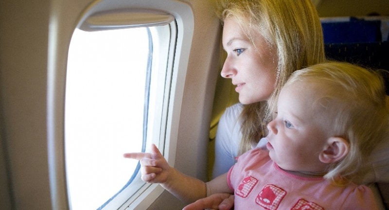 mum and baby boy looking out of a plane windown