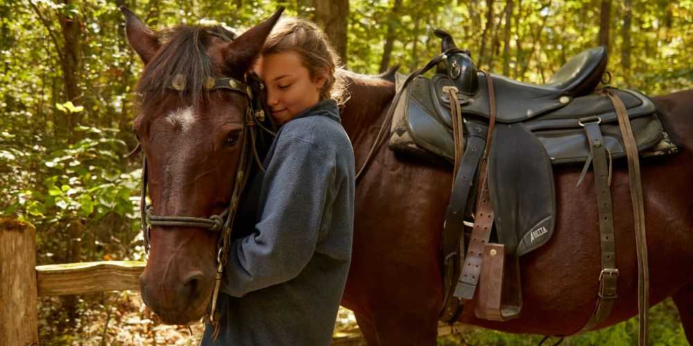 teenager-standing-with-gentle-chestnut-pony-in-a-forest-in-kentucky-family-traveller-2022
