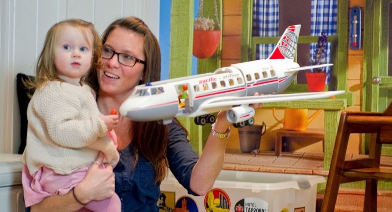 Mum and daughter playing with toy plane