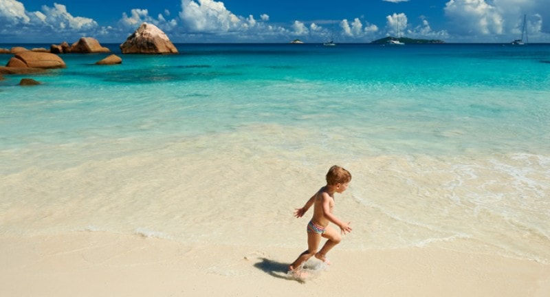 Little boy running on a beach in the seychelles