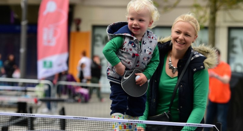 a mother and her young soon playing ping pong at ping festival in london