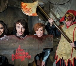 children with their heads in a block enjoying london dungeons