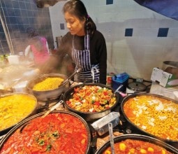 large pans of rice dishes being served on the street in london