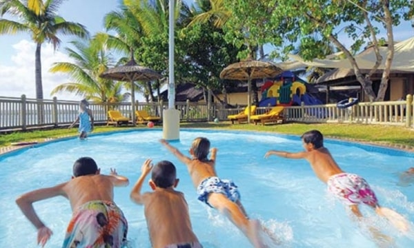 teenagers play in swimming pool in mauritius resort