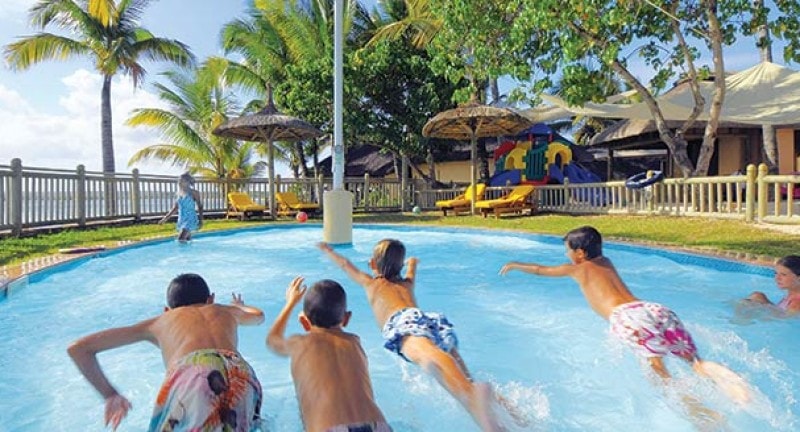 teenagers play in swimming pool in mauritius resort