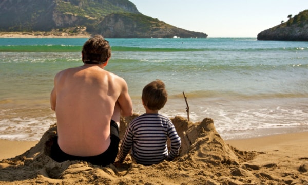 Simon Reeve and his son on the beach in Greece