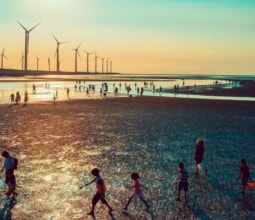people-on-beach-in-front-of-wind-turbines
