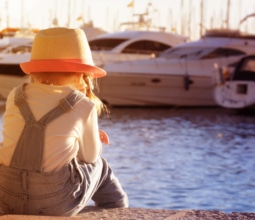 little-girl-at-port-with-yachts-in-marina-sunshine