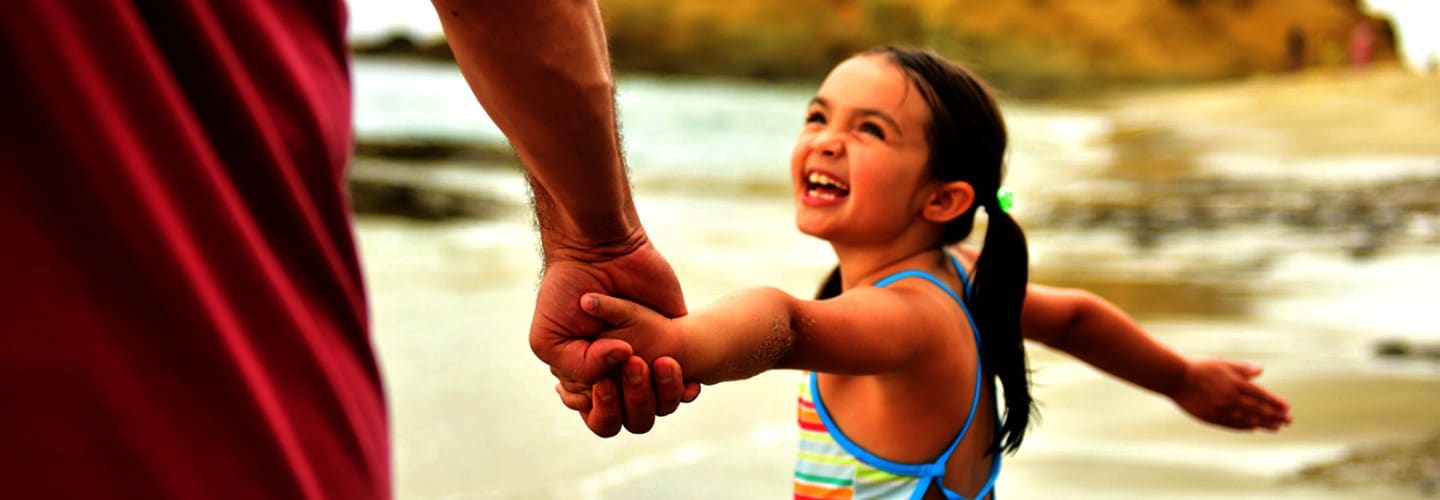 girl holding fathers hand california