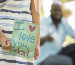 Happy Father's Day. Girl gives card to dad.