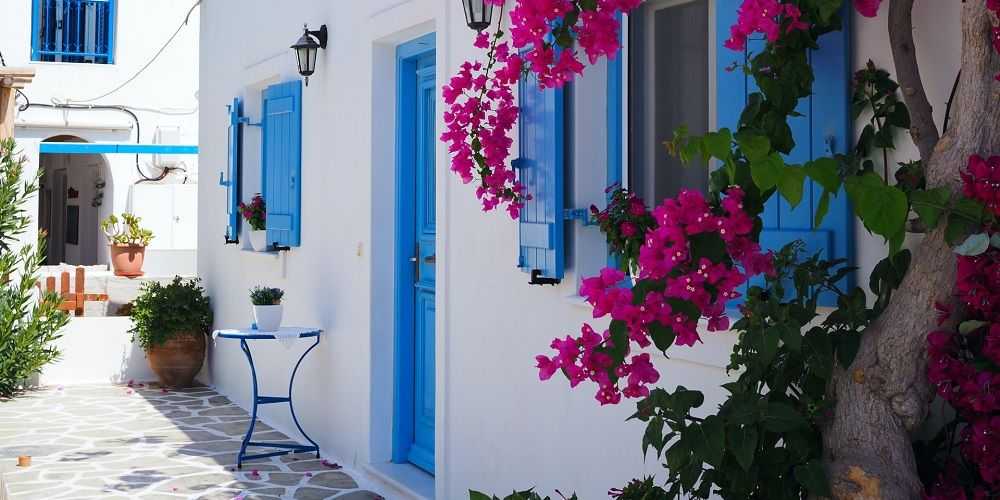 whitewashed-village-house-blue-shutters-pink-bougainvillea-antiparos-greece