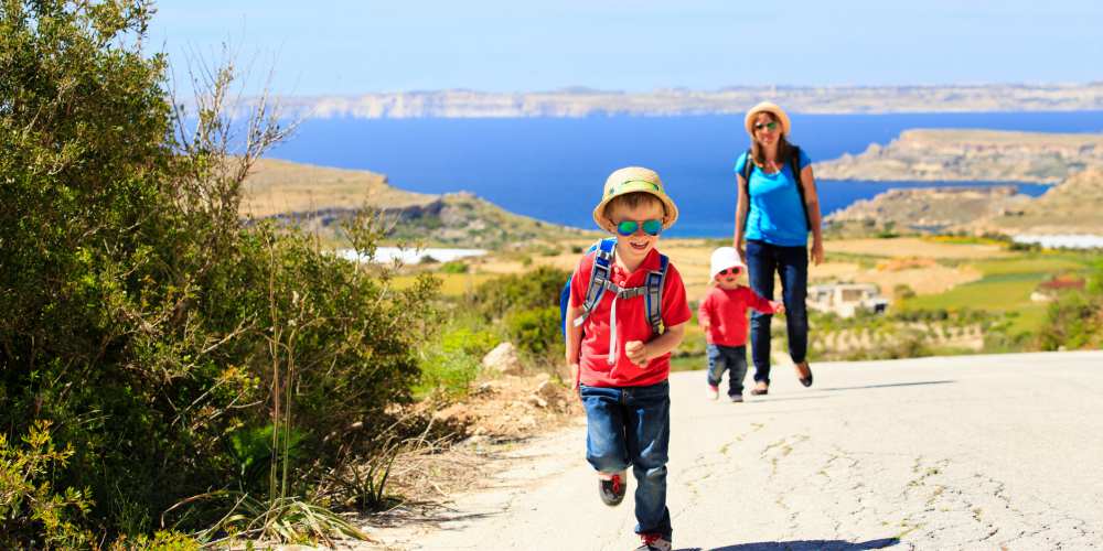 young-kids-and-their-mother-walking-the-sunny-coast-on-Gozo-Malta-easter-family-holidays-
